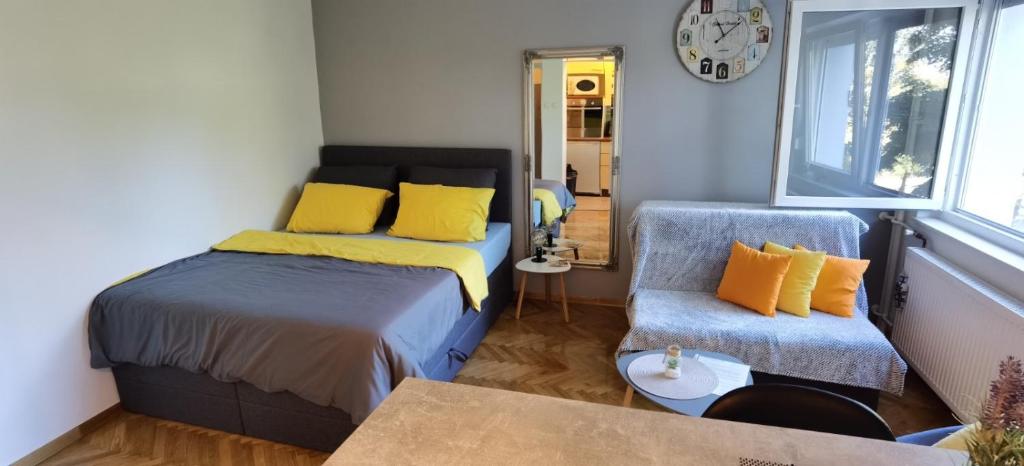 a bedroom with a bed and a chair and a clock at Studio apartman Tonka in Vinkovci