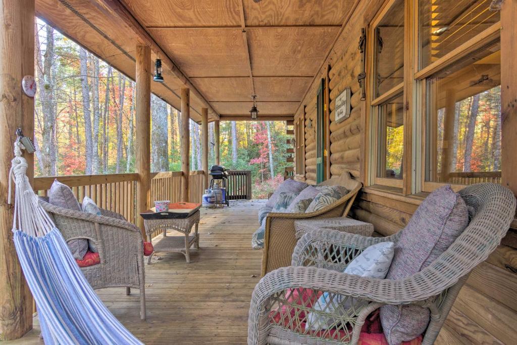 une véranda dans une cabane en bois avec des chaises et une table dans l'établissement Cedar Mountain Log Cabin 4 Mi DuPont State Forest, à Cedar Mountain