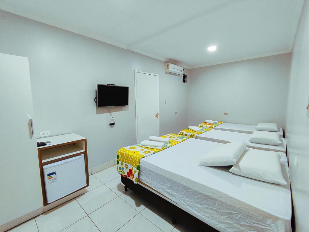 a bedroom with a large bed and a tv at Barra Nova Hotel in Saloá