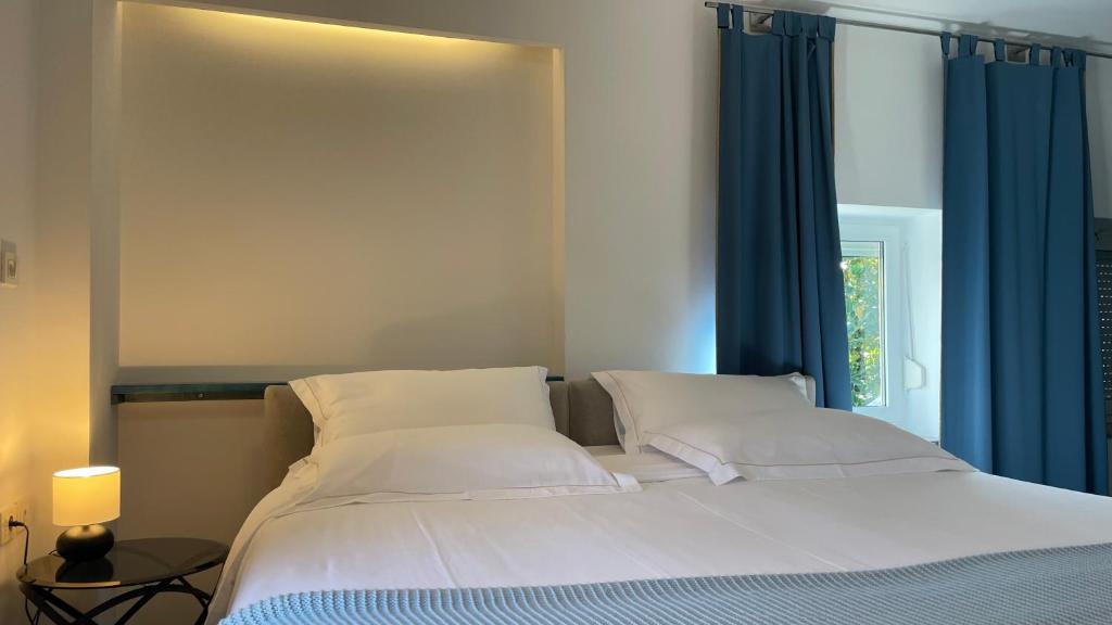 una camera da letto con un grande letto con tende blu di MADONCA ROOMS & RESTAURANT a Nova Gorica