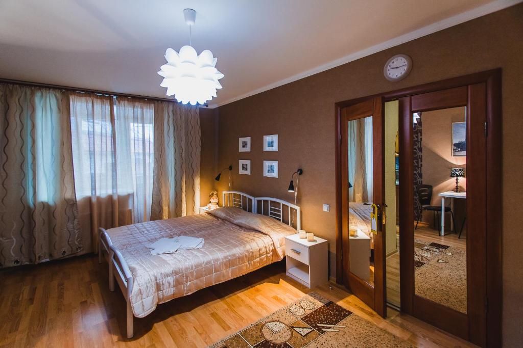 Schlafzimmer mit einem Bett und einem Kronleuchter in der Unterkunft Tri Zaytsa in Murmansk