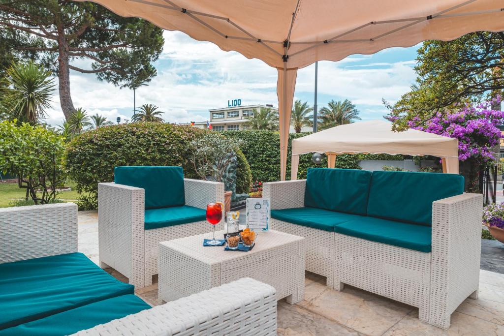 patio z krzesłami, parasolem i stołem w obiekcie Hotel Santa Maria w mieście Chiavari