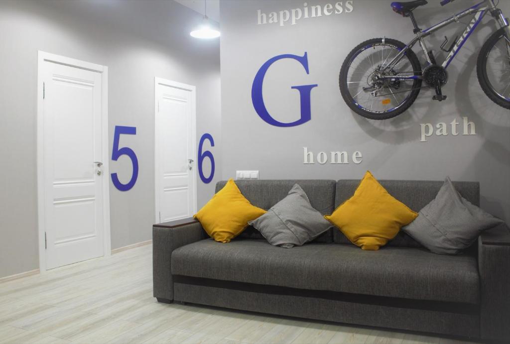 eine Couch mit Kissen und ein Fahrrad hängt an der Wand in der Unterkunft O'Key Home in Rostow am Don
