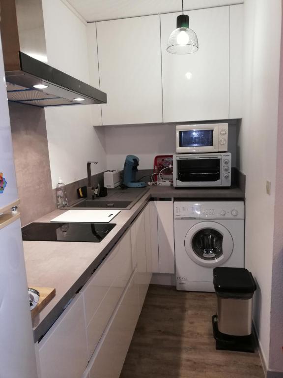 a kitchen with a washing machine and a microwave at Appartement avec terrasse in Saint-Cyprien-Plage