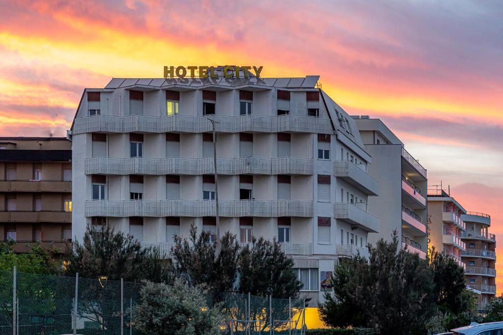 a hotel building with a hotel sign on top of it at Hotel City in Milano Marittima