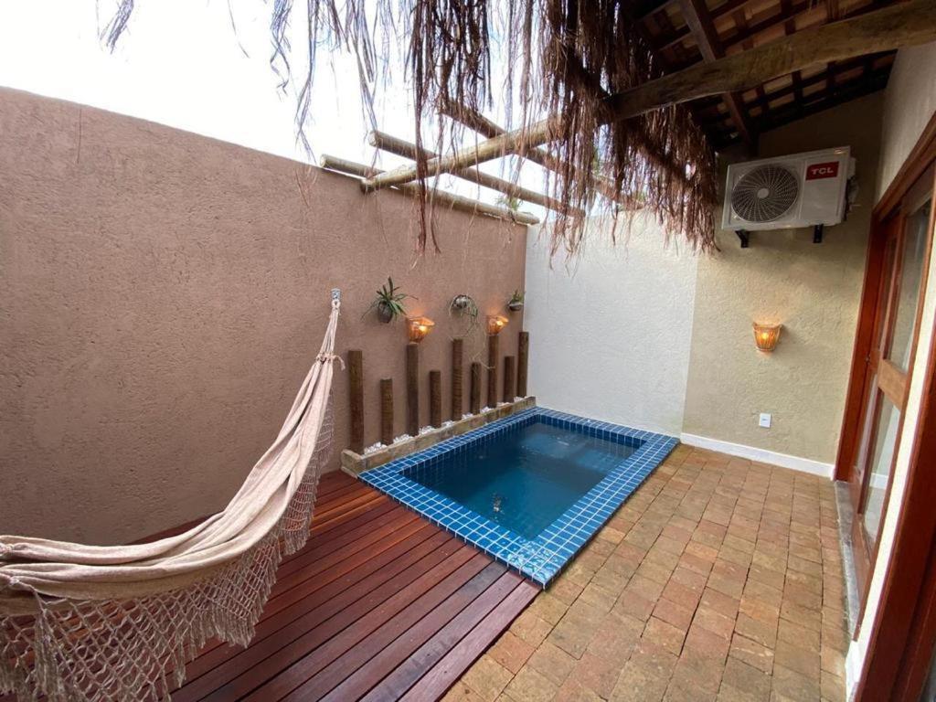 a hammock and a swimming pool in a house at Naim Milagres in São Miguel dos Milagres