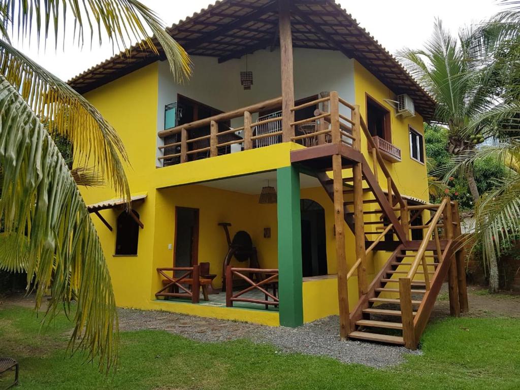 a yellow house with a staircase in front of it at Casa Praia dos Anjos in Barra Grande