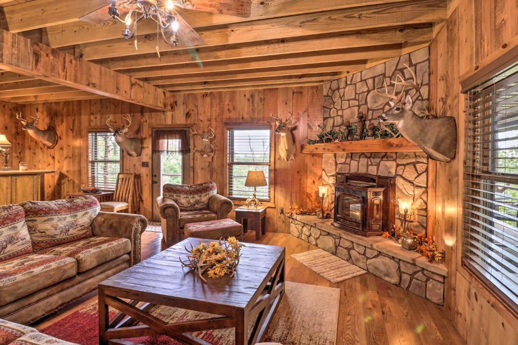uma sala de estar com uma lareira de pedra num chalé de madeira em Quiet and Rustic Cabin with Fire Pit on 20 Acres! em Hardy
