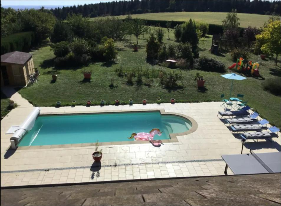 una vista aérea de una piscina con una persona en traje de baño en LE GITE DE VERONIQUE,jo 2024, en Turny