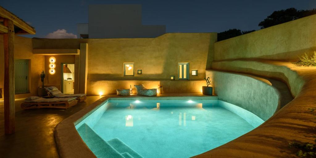 a swimming pool in a backyard at night at Potamos Luxury House, Private Pool, Santorini in Éxo Goniá