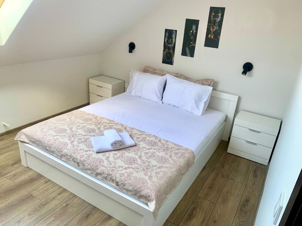 um quarto com uma cama branca com duas toalhas em ,,Адела”-апартамент за гости em Velingrad