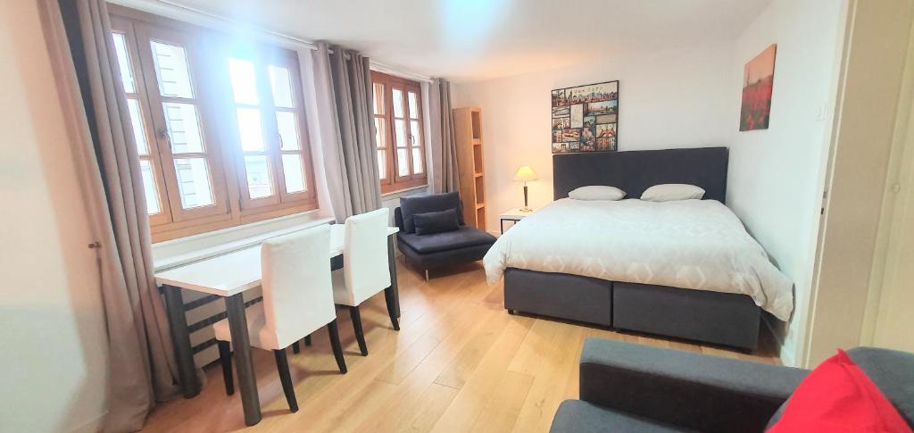 een slaapkamer met een bed en een tafel en stoelen bij Boël 3 studio in Genève