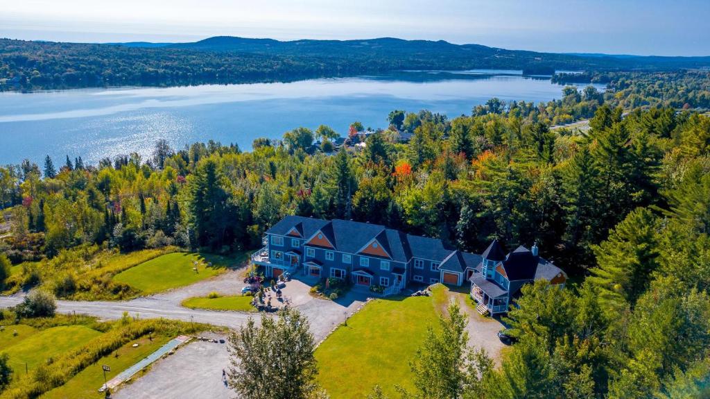 - une vue aérienne sur une grande maison sur une colline à côté d'un lac dans l'établissement Location Au Sommet du Lac Magog, à Magog