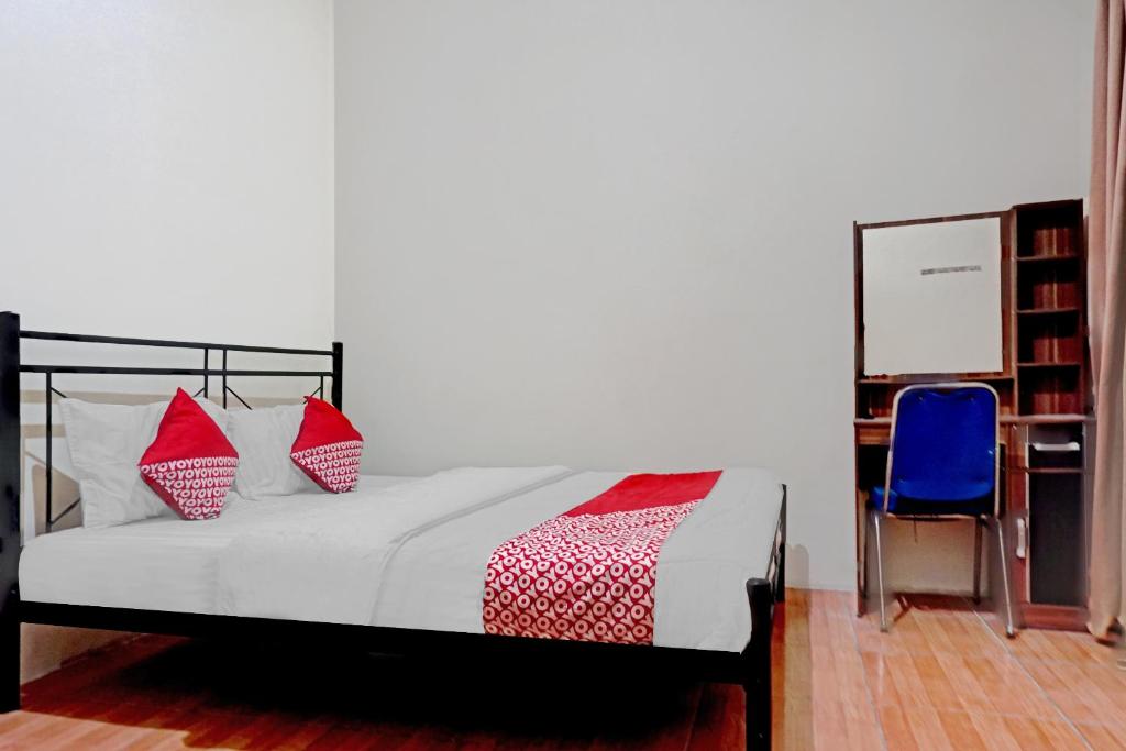 a bedroom with a bed and a blue chair at SUPER OYO 90689 Lily House in Tangerang