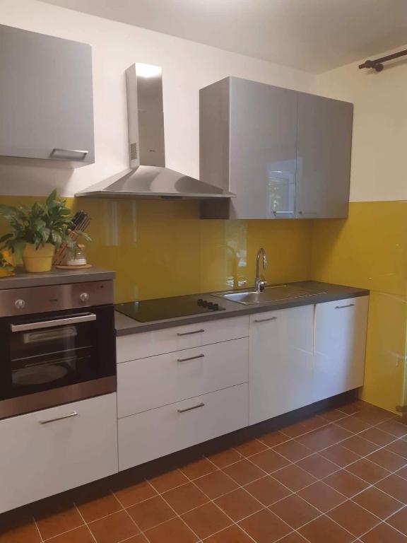 kuchnia z białymi szafkami, zlewem i kuchenką w obiekcie Apartment near centar for 2+1 at Pula, with garden and free parking w Puli