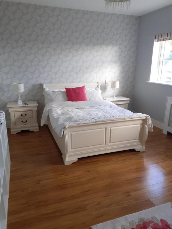 1 dormitorio con cama blanca y almohadas rojas en Private Room in Superb House Bed 1 en Nobber