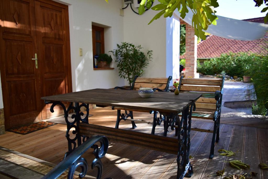 una mesa de madera y un banco en un patio en Kéktúra vendégház en Óbánya
