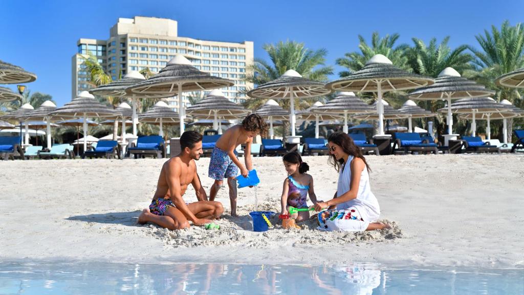 people sitting on top of a beach at InterContinental Abu Dhabi, an IHG Hotel in Abu Dhabi