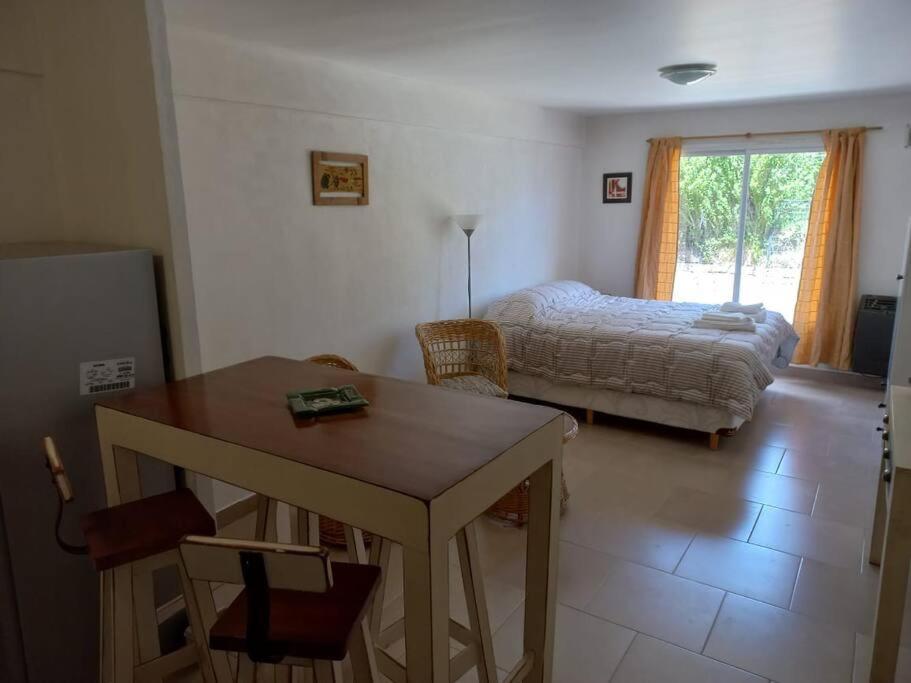 - un salon avec une table et un lit dans l'établissement Departamento Albarracin, à San Carlos de Bariloche
