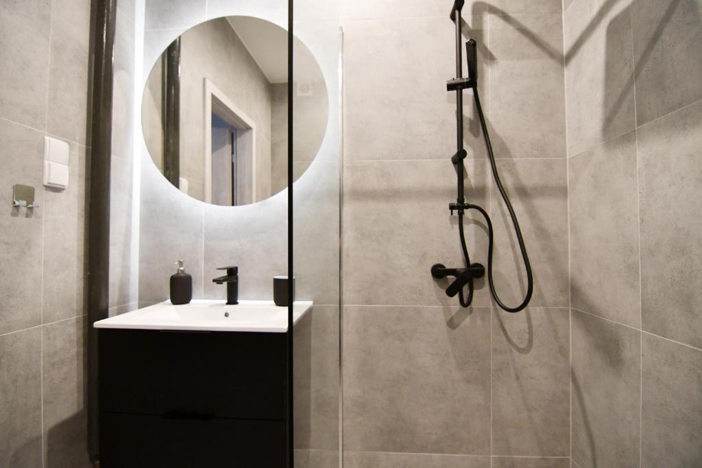 łazienka z prysznicem, umywalką i lustrem w obiekcie Apartament Szafirowy MULTI HOUSE w mieście Rzeszów