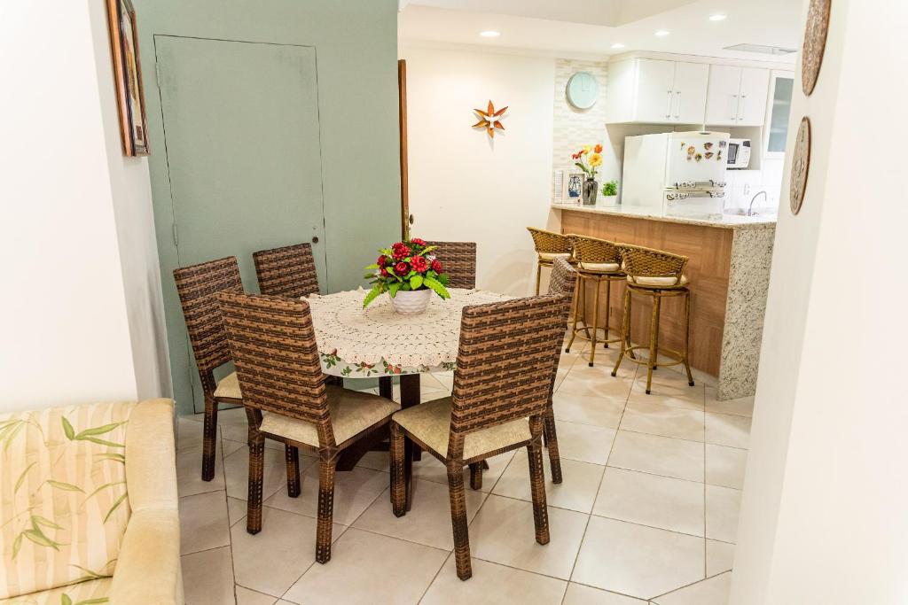 ein Esszimmer und eine Küche mit einem Tisch und Stühlen in der Unterkunft Apto a 250m da Praia do Tombo no Guaruja-SP in Guarujá