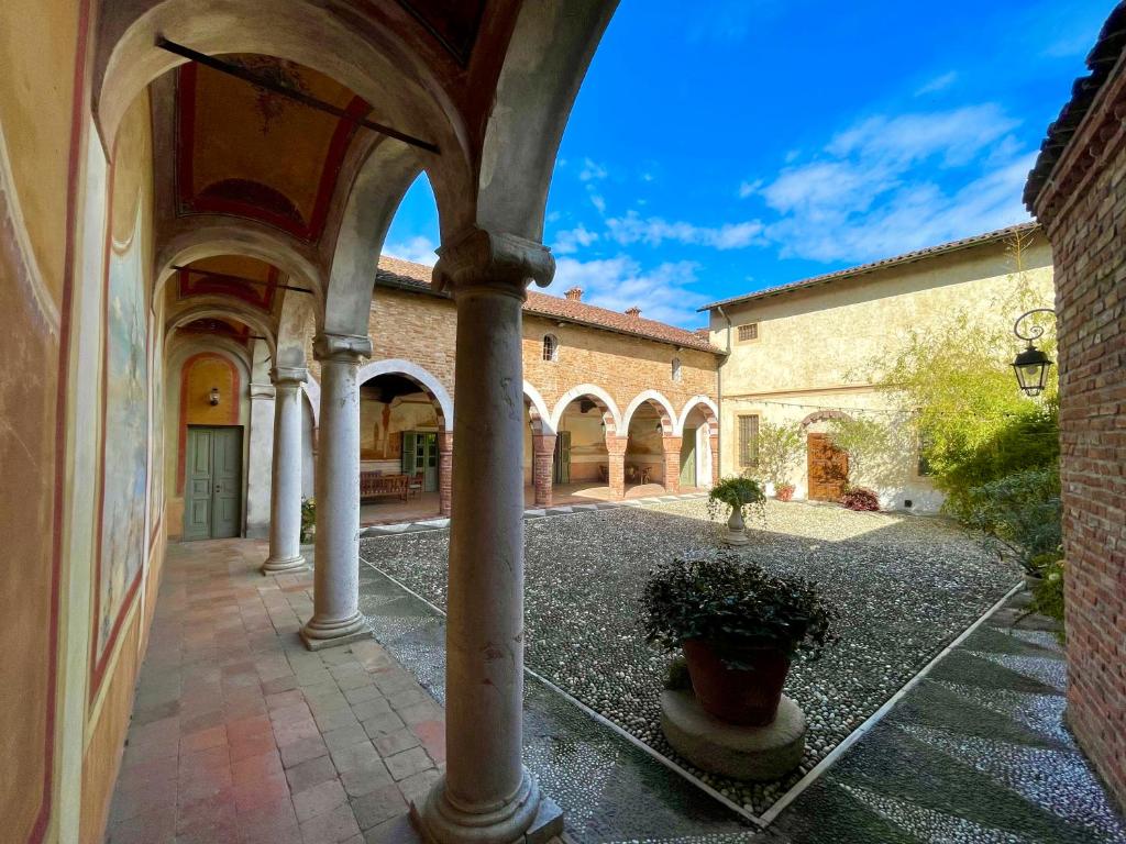 un edificio con un pilar con una maceta en un patio en Villa Bottini ideale per relax di lusso, en Robecco dʼOglio