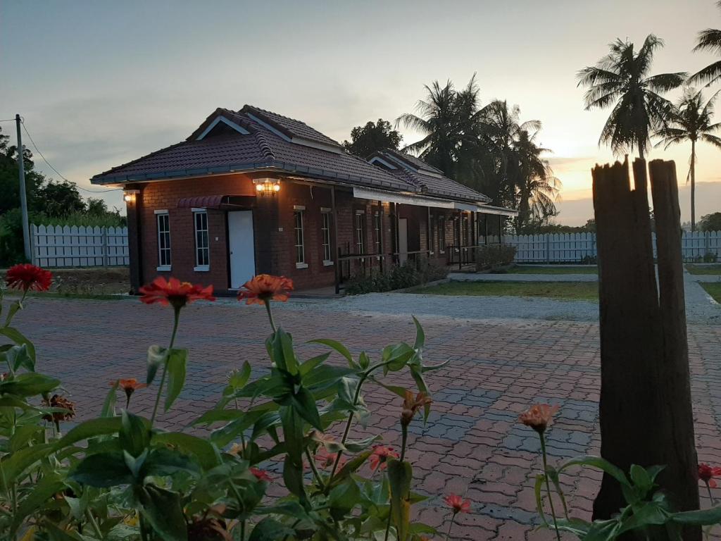 une petite maison avec une route en briques devant elle dans l'établissement GekQ Inn Langkawi B, à Pantai Cenang