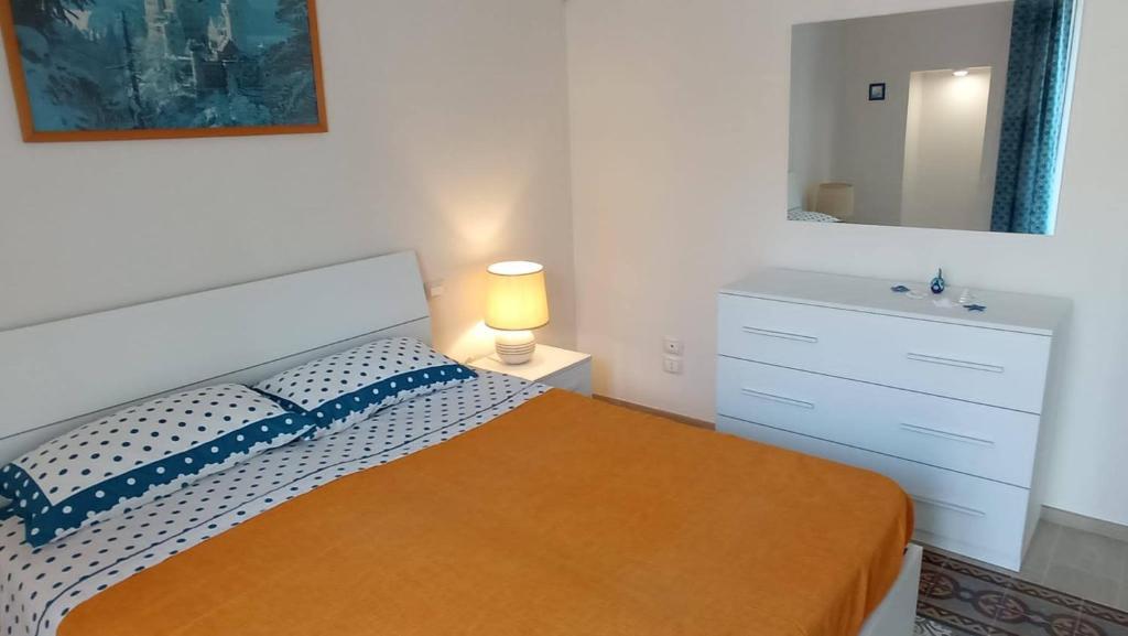1 dormitorio con cama, lavabo y espejo en La casa di Trilly, en Mola di Bari