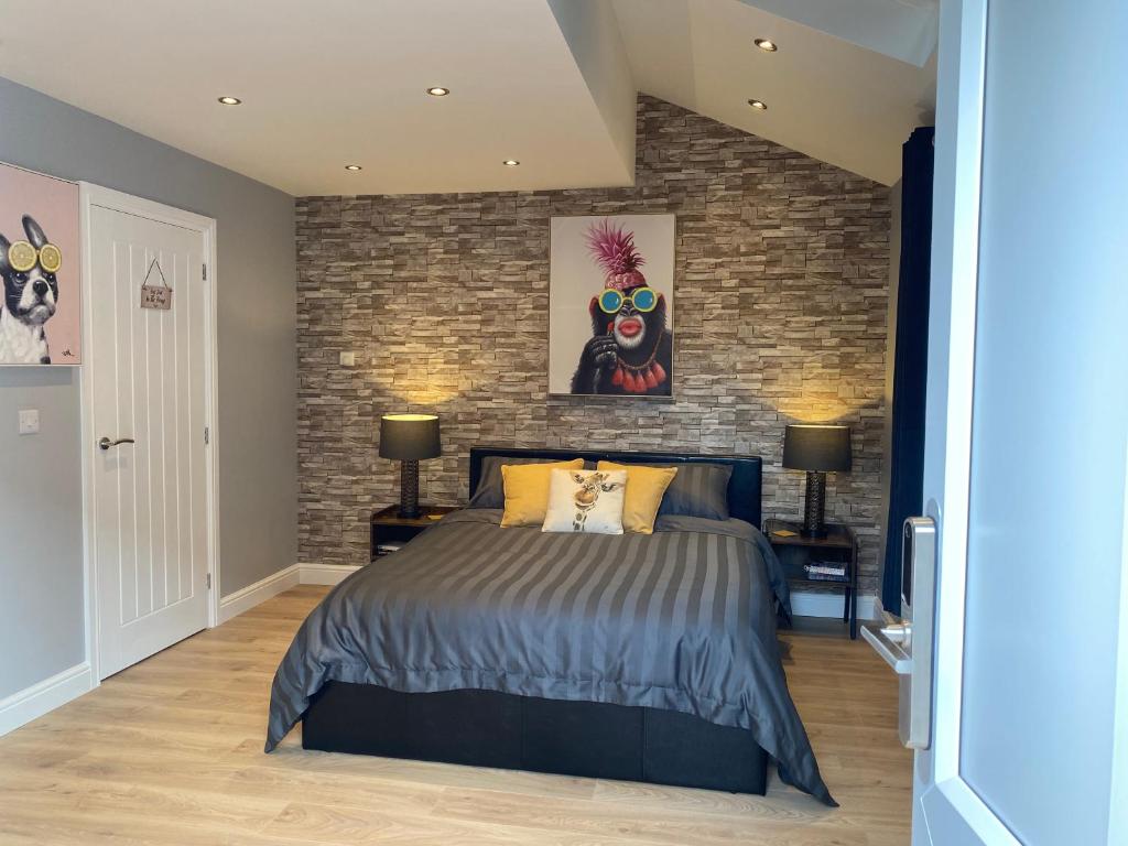 a bedroom with a bed and a brick wall at Modern Luxury 1 bed apartment with parking near Stansted Airport in Stansted Mountfitchet