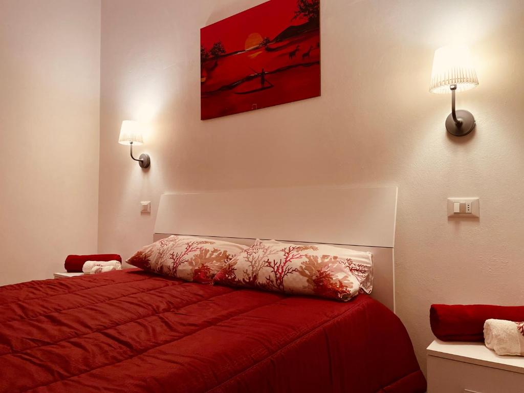a bedroom with a bed with a red bedspread at Casa Norma in Sottomarina