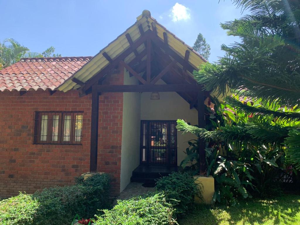 a red brick house with a wooden door at Villa Maria Paula in Jarabacoa