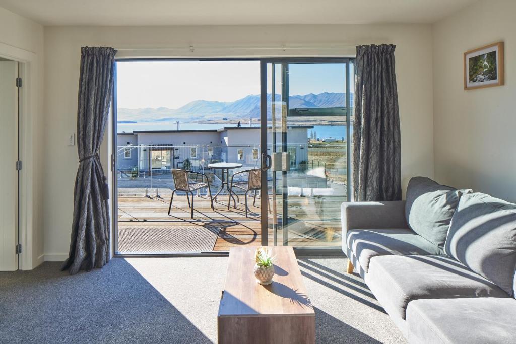 a living room with a couch and a table at Alpine View Apartment 2 - Tekapo in Lake Tekapo