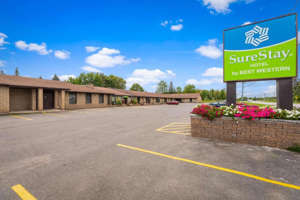 a building with a sign in a parking lot at SureStay Hotel by Best Western Kemptville in Kemptville