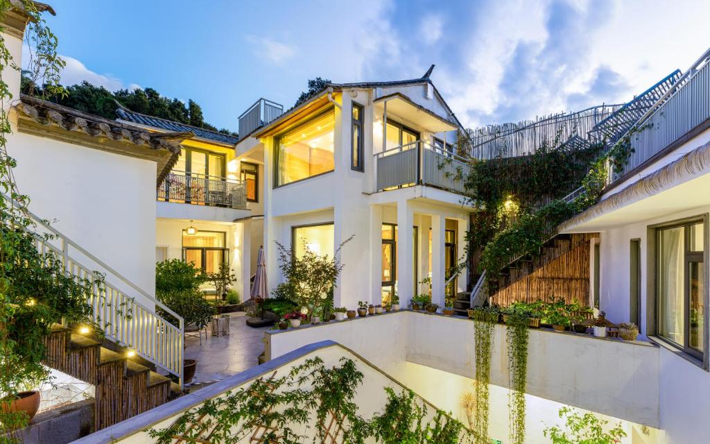 a home with a staircase leading up to it at Xinyue Suying Holiday Hotel in Tengchong