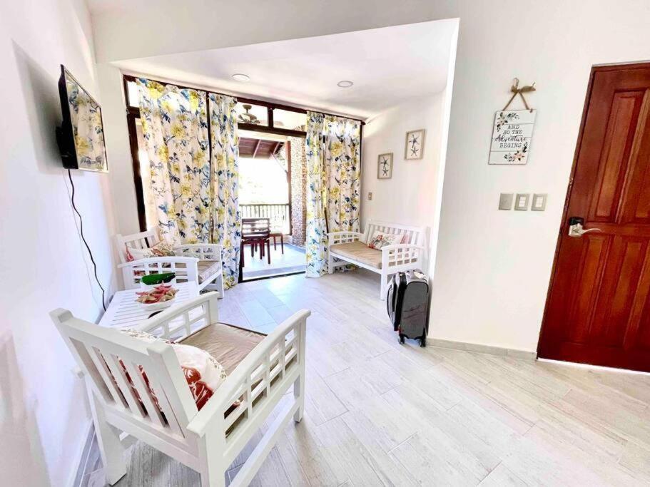 una sala de estar con 2 cunas blancas en una habitación en Las Terrenas beachfront 2 bedrooms condo with pool, en Las Terrenas