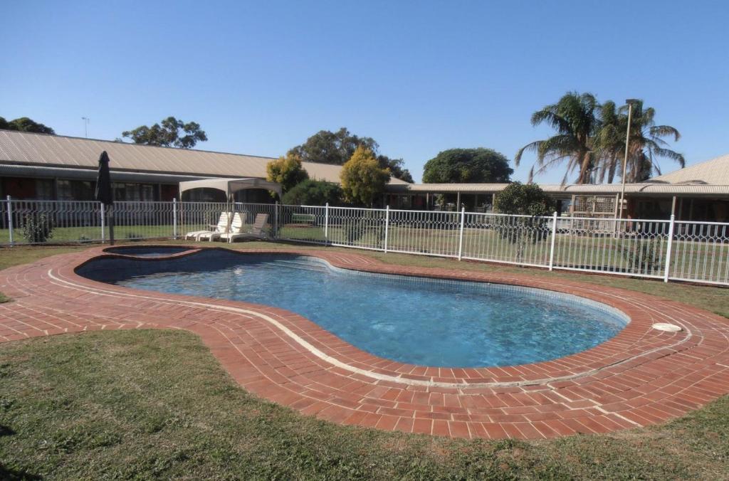 a swimming pool with a brick pathway around it at All Rivers Accommodation in Echuca