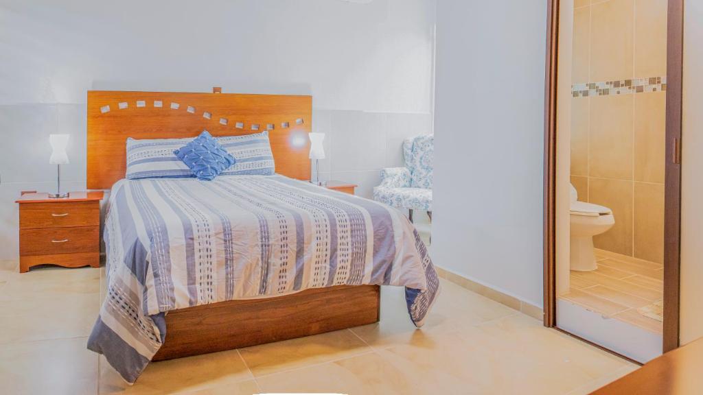 een slaapkamer met een bed en een badkamer met een toilet bij Casa Mariano in Morelia