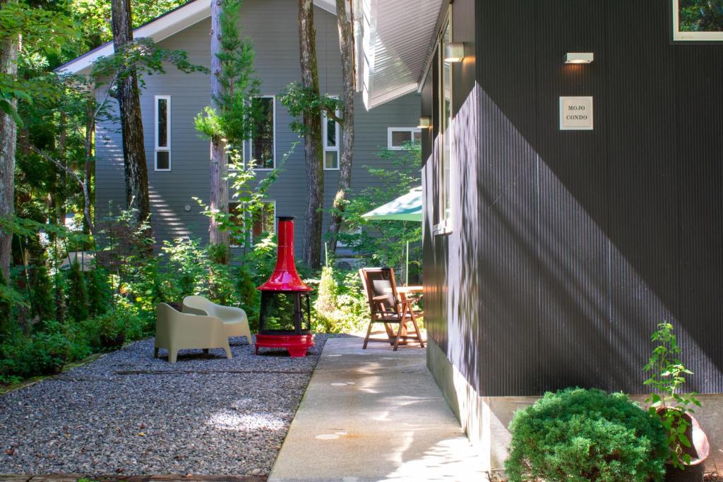 un patio con un jarrón rojo en el lateral de una casa en Mojo Lodge Hakuba en Hakuba