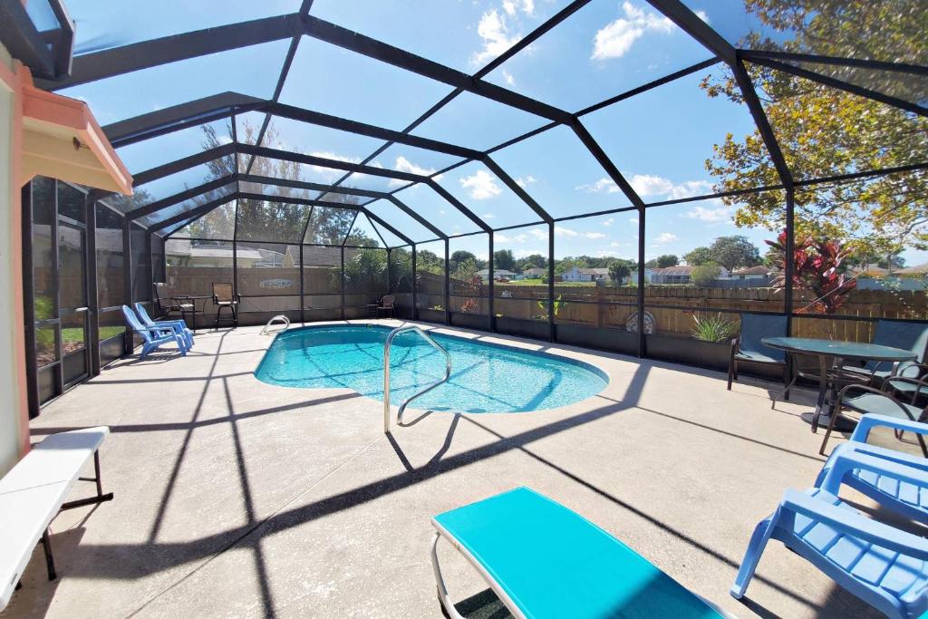 a swimming pool in a glass house with a patio at 1050 Tompkins Drive in Port Orange