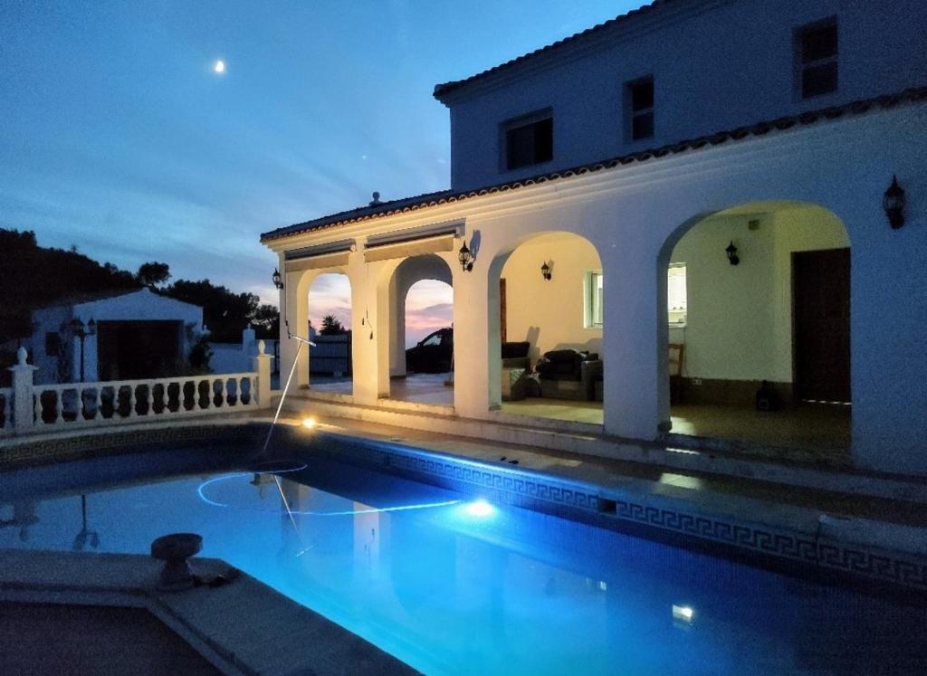 a villa with a swimming pool at night at Villa Tranquila Arenas Malaga in Arenas