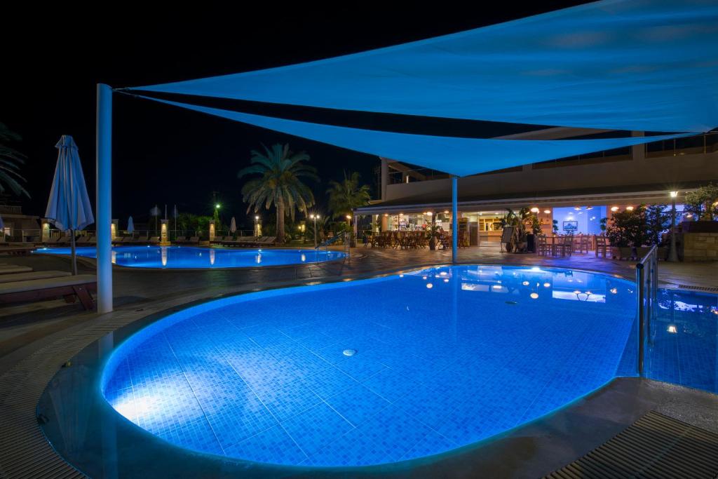a swimming pool at night with a blue illumination at Isida Hotel Agia Marina in Agia Marina Nea Kydonias