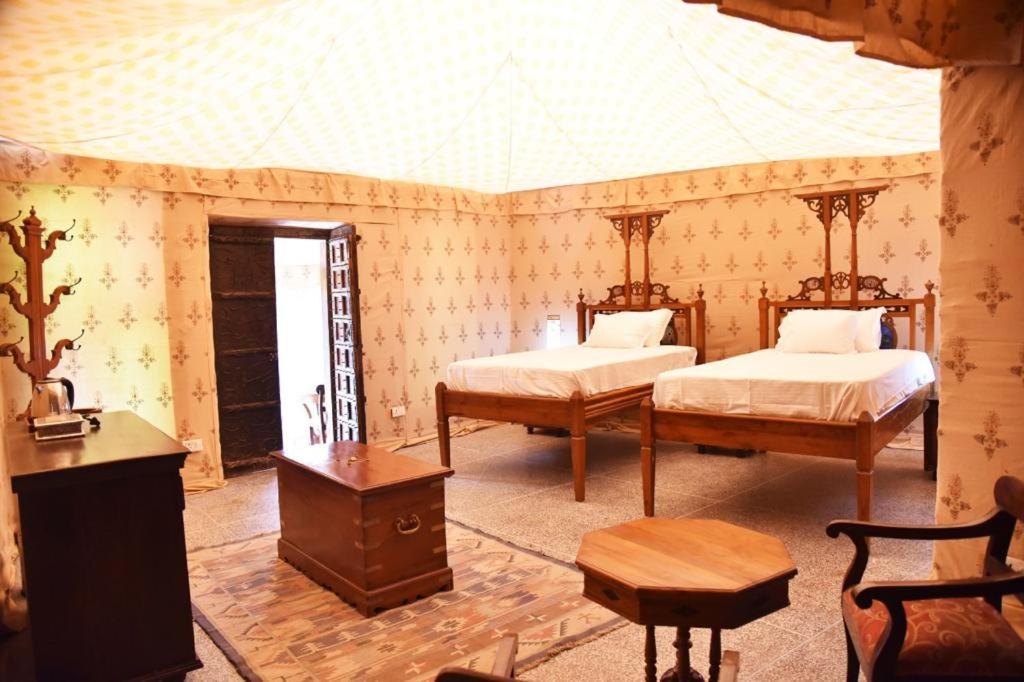 - une chambre avec 2 lits, une table et des chaises dans l'établissement Osian The Desert Boutique Hotel, à Khāra