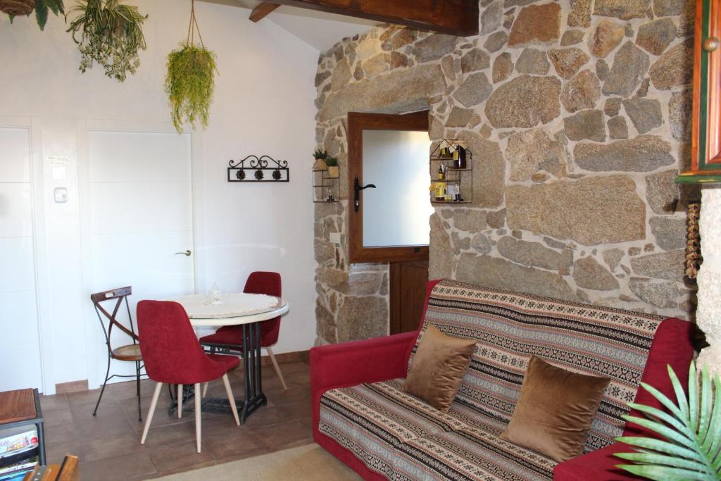 ein Wohnzimmer mit einem roten Sofa und einem Tisch in der Unterkunft Casa Rural A Gorgoriña in Cangas