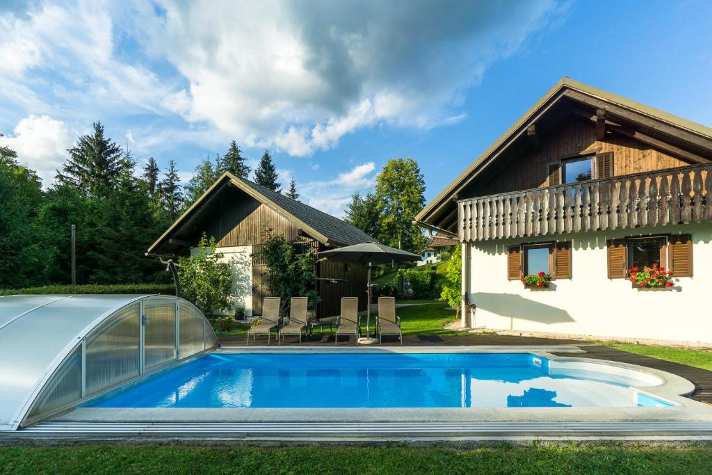 a swimming pool in front of a house at Holiday House in Nature with Pool, Pr Matažič in Kamnik