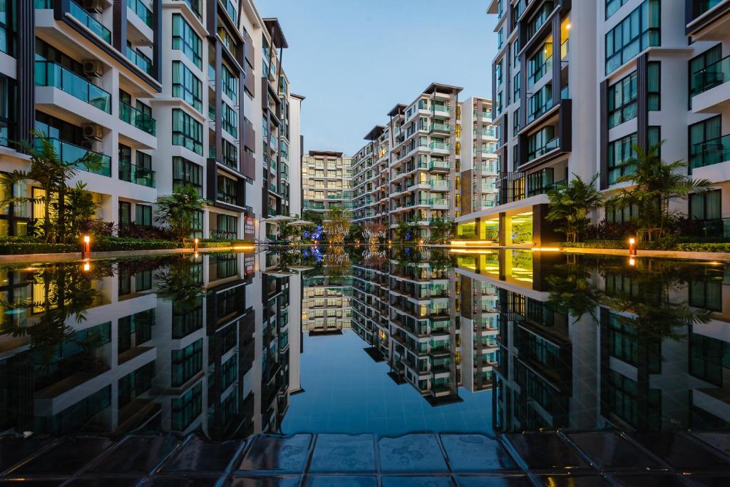 un reflejo de edificios en una masa de agua en Wyndham Royal Lee Phuket, en Nai Yang Beach