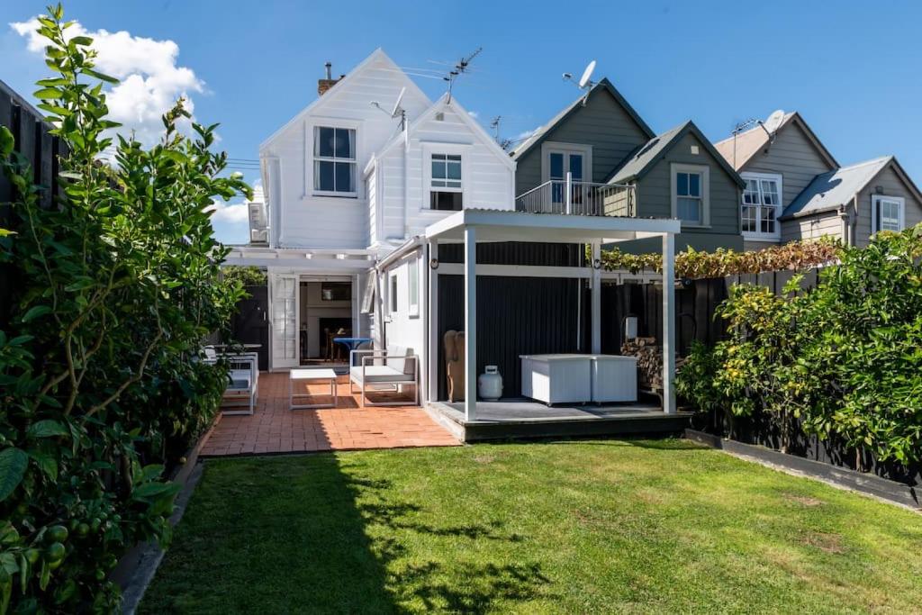 a white house with a gazebo in a yard at Timeless 2BR Grey Lynn Cottage - Fibre - WiFi in Auckland
