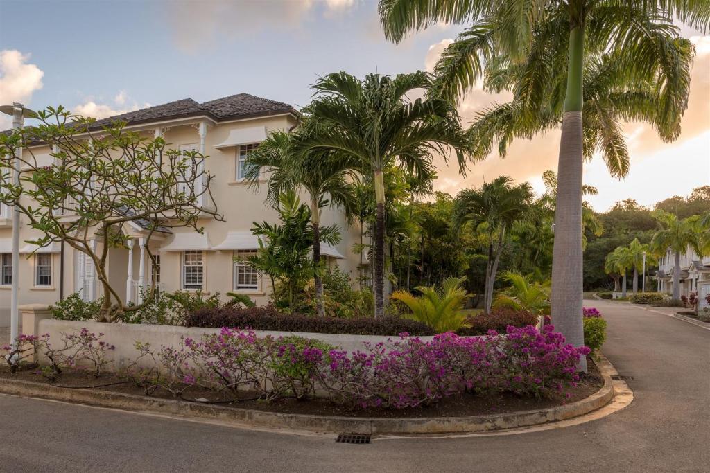聖彼得的住宿－Shimmers, stunning, stylish West Coast Villa，街上棕榈树和鲜花的建筑