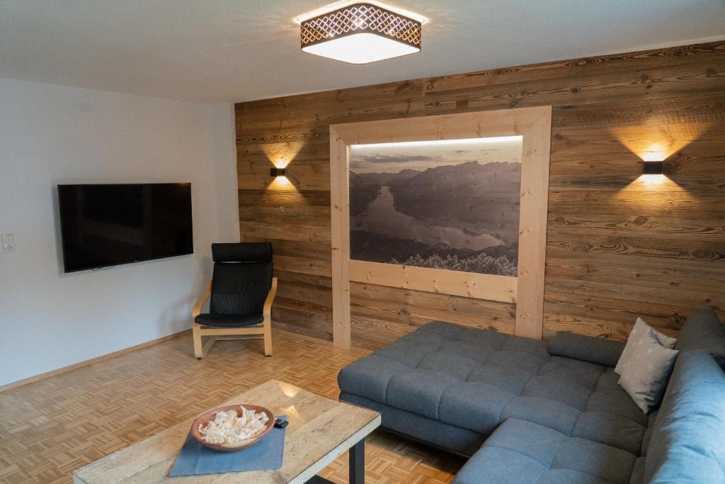 sala de estar con sofá azul y TV en LUSE Living, en Maurach