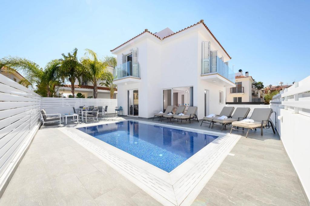 a villa with a swimming pool and a house at Villa Elaine in Protaras