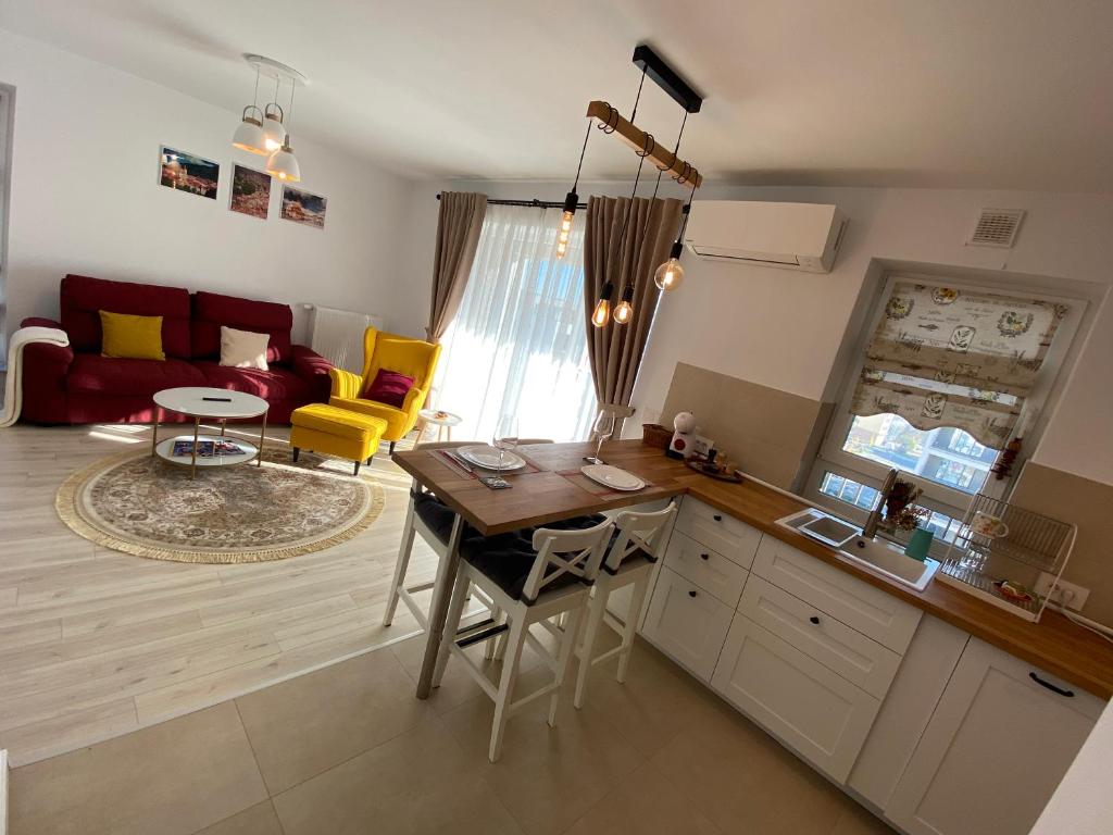 kuchnia i salon ze stołem i żółtymi krzesłami w obiekcie Relax601 w Braszowie